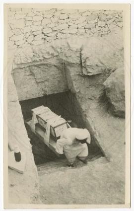 Carrying a chest up the tomb's rockcut staircase