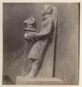 Uninscribed statue of a priest holding a ram's head, black stone, Dyn. XIX, provenance not known,...